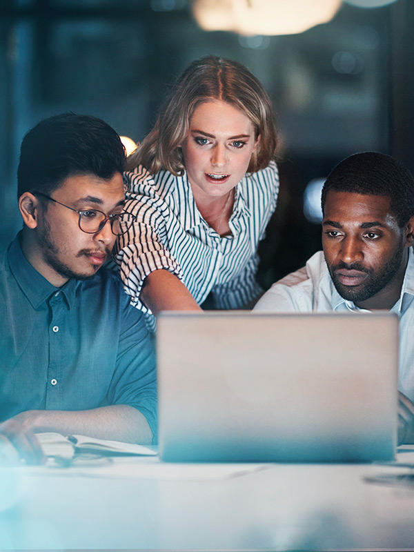 Équipe de professionnels collaborant sur un projet devant un ordinateur portable au bureau