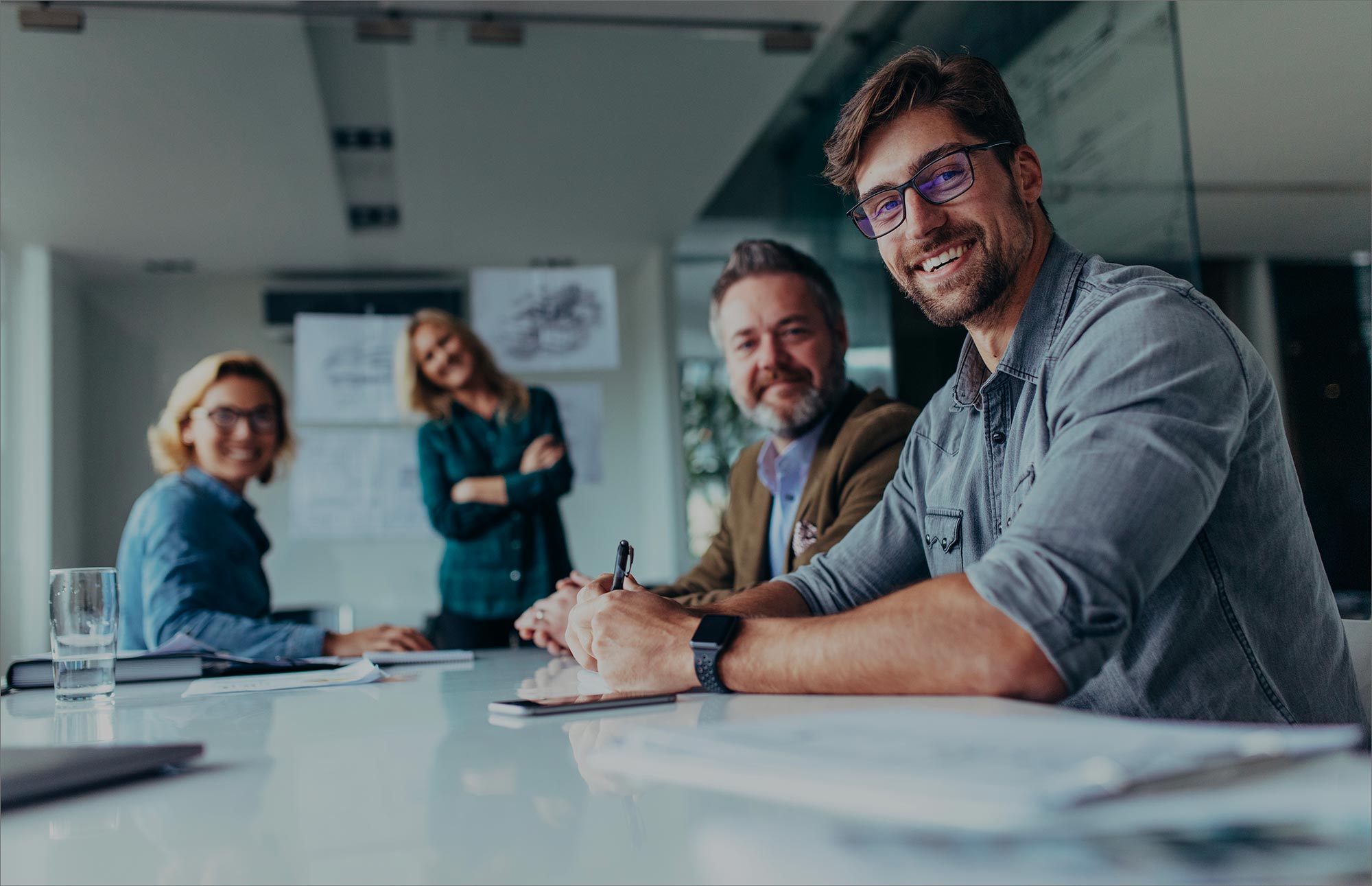 Équipe de professionnels souriants lors d'une réunion d'affaires dans une salle de conférence moderne