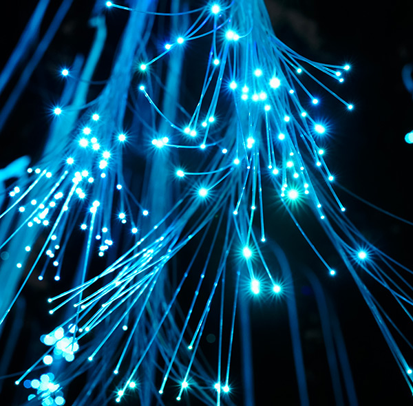 Fibres optiques lumineuses illustrant la transmission haut débit des réseaux de télécommunications